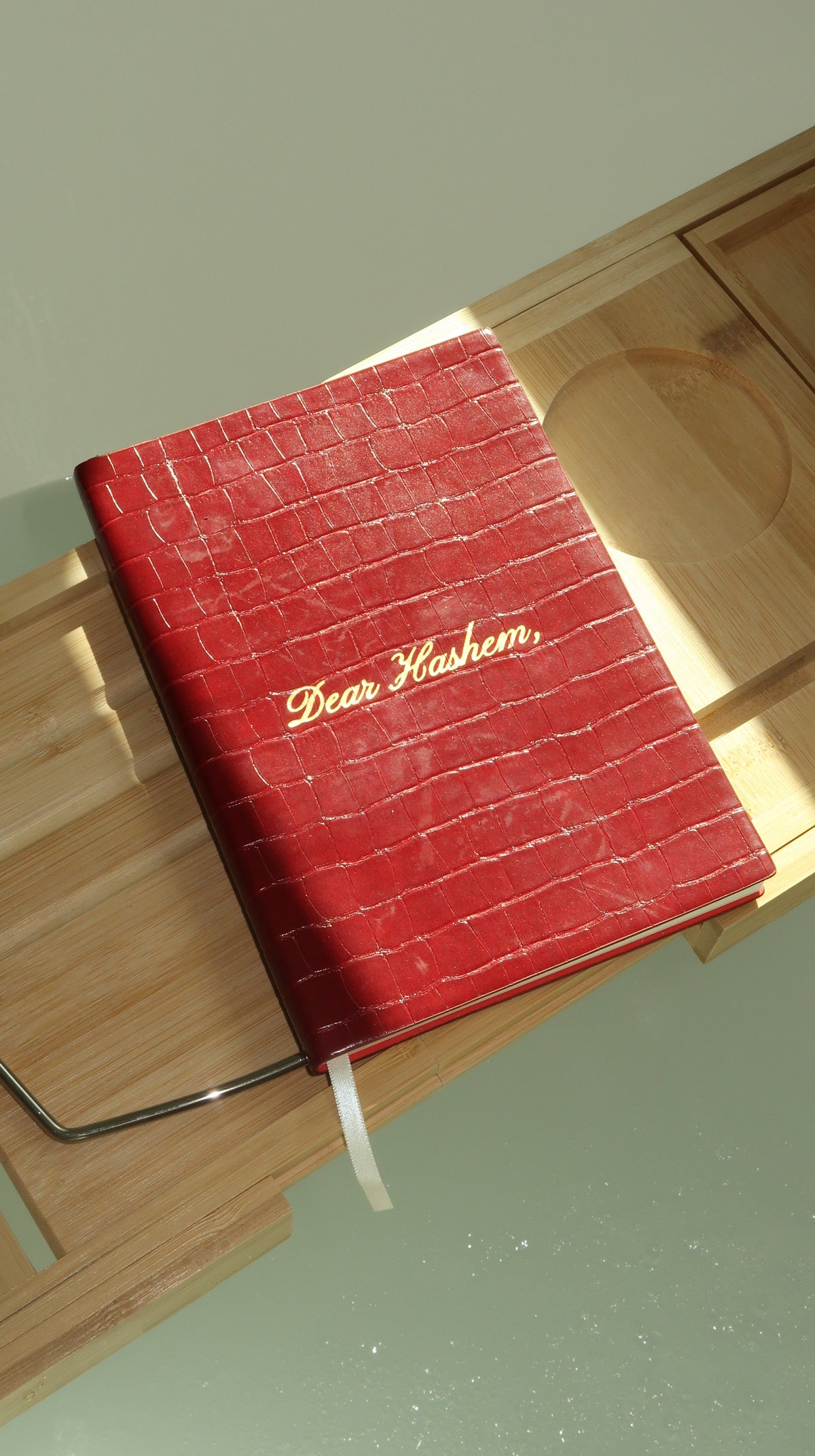 Cherry Dear Hashem Journal in natural light on a wooden bath tray